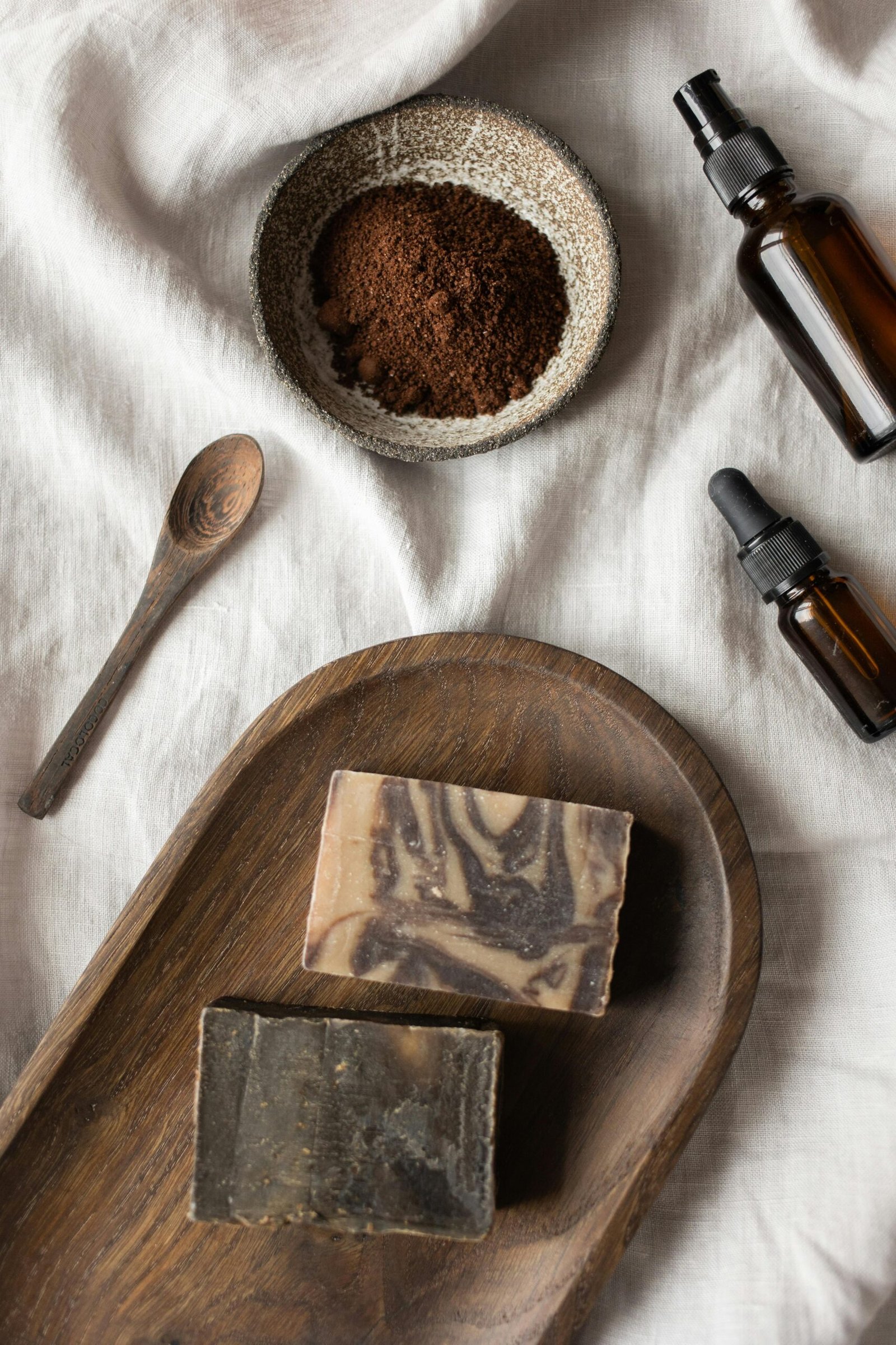 Flat lay of natural skincare products including soaps, essential oils, and clay for a calming spa experience.